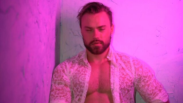 Portrait of a muscular handsome blonde man in slow motion. Fashion model trendy studio photography with vintage colored lights