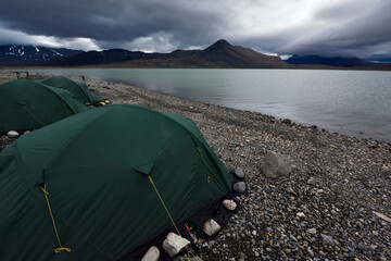 View looking over the three green tents at base camp on the shore of lake Centrum S��.; Northeast Greenland , Greenland