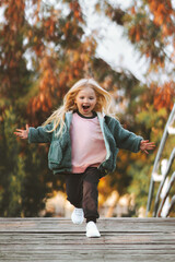 Child running in a park happy laughing travel vacations outdoor family lifestyle autumn season