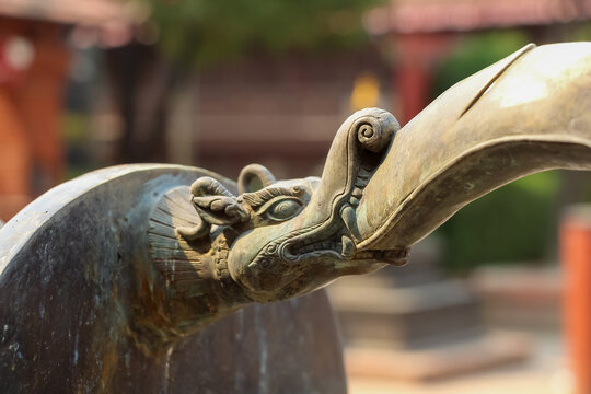 Close-up view of bronze Yali (Hindu mythological creature with trunk of elephant) head decoration located in one of courtyards (bahals) in Lalitpur city, Nepal. Soft focus. Culture of India.