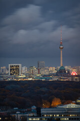 Fototapeta premium The illuminated skyline of Berlin Mitte, Germany, during winter dusk with moody sky