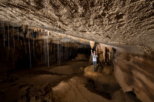 Researcher exploring stalagmites in a cave in Gunung Mulu National Park; Sarawak, Borneo, Malaysia