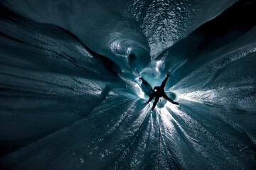 A cave explorer descending down into a moulin on the Aletsch Glacier.