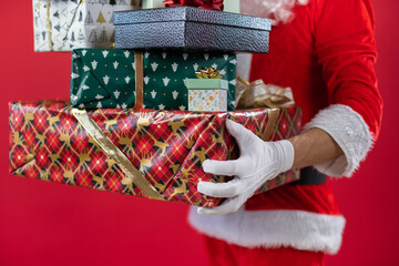 
Portrait von einem verkleideten Weihnachtsmann mit Geschenk, isoliert auf roten Hintergrund im Studio 