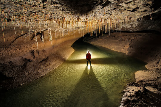 A Mulu Cave Project expedition member in the Whiterock river in Whiterock cave.