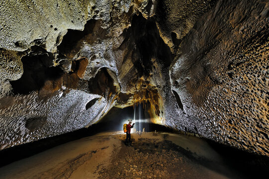 A Mulu Cave Project expedition member examines a scalloped rock wall in Clearwater cave.