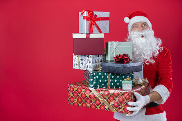 Portrait von einem verkleideten Weihnachtsmann mit Geschenk, isoliert auf roten Hintergrund im Studio im Querformat