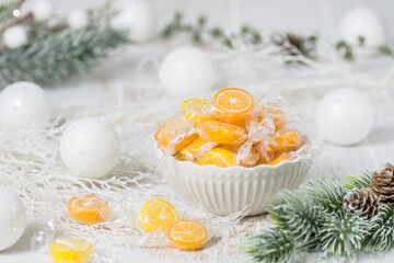 Bowl with candies in the form of orange and lemon slices, individually wrapped in foil