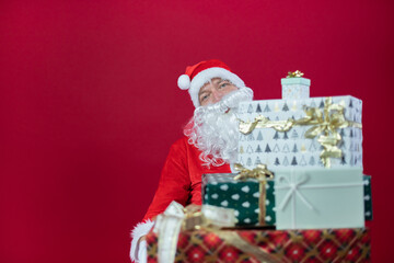 Portrait von einem verkleideten Weihnachtsmann mit Geschenk, isoliert auf roten Hintergrund im Studio im Querformat