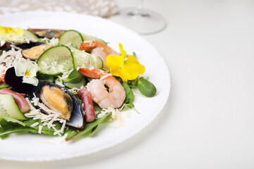 Plate of delicious salad with seafood on white table, space for text