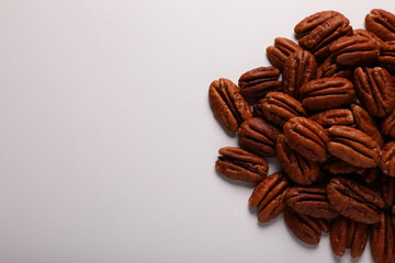 Pile of delicious fresh pecan nuts on white background, top view. Space for text