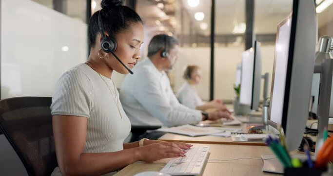 Customer service, call center and black woman typing on computer at night. Contact us, crm telemarketing and group of employees, sales agents or consultants on pc working late in company workplace.