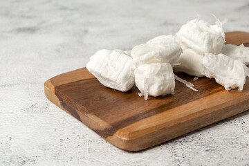 bala de coco or brazilian coconut candy, a gourmet homemade sweet dessert made of coconut over wooden table