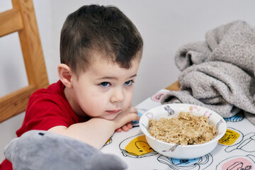 cute young boy being patient while waiting for his food to cool down