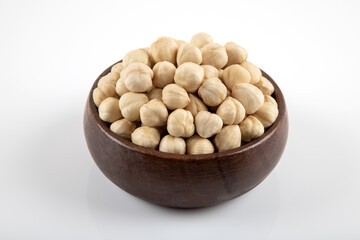 View of a bowl full of hazelnuts on white background
