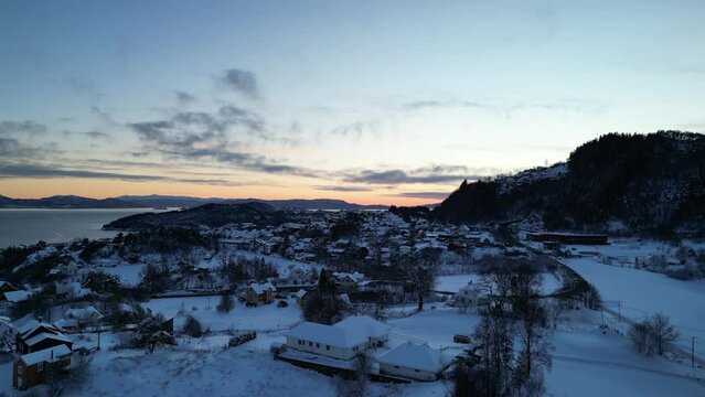 Sunset over Norwegian coastal landscape. Winter, mountains and fjord.