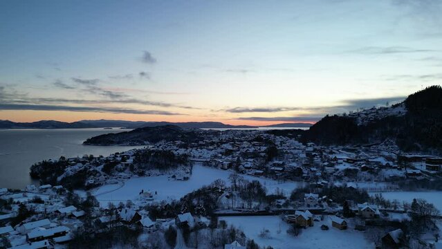 Sunset over Norwegian coastal landscape. Winter, mountains and fjord.