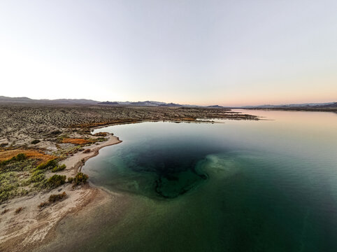 wide angle view from aerial view drone shot of lake mohave in the national recreation area of lake mead in nevada and arizona with the sun setting showing six mile cove and its sand