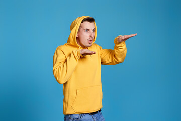 Fototapeta na wymiar positive funny man in yellow sweatshirt dancing