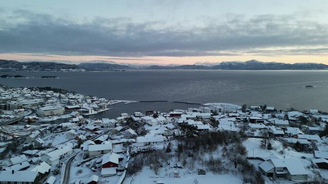 Sunset over Norwegian coastal landscape. Winter, mountains and fjord.