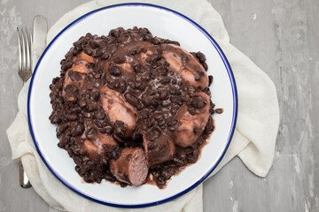 black beans stew with sausages on a white dish