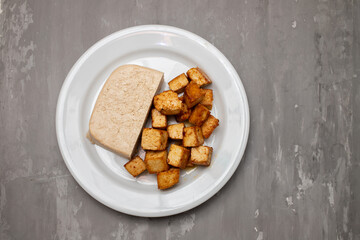 raw tofu block on white small dish on ceramic