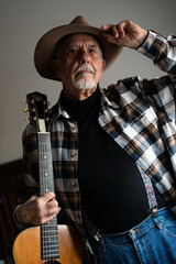 Portrait of senior man with hat and guitar. Blues and country musician
