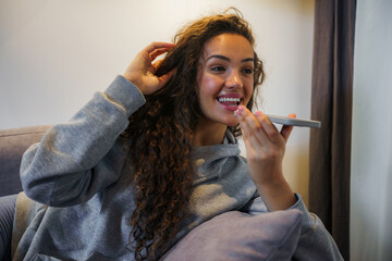 Young woman talking on the phone over a speaker, she's smiling and enjoying her talk with friends or boyfriend