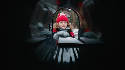 POV Cute little kid boy puts a letter with his Christmas wishes addressed to Santa Claus, Notrh Pole into the mailbox