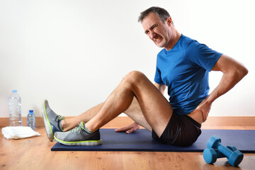 Man doing sports indoors complaining of lower back pain