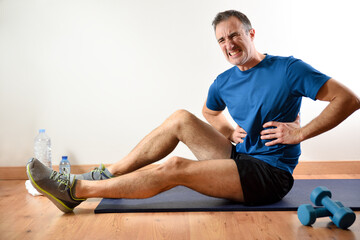 Man doing sport indoors complaining with ribs pain