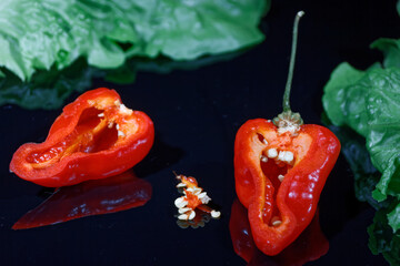 red habanero chili pepper shown on a black reflecting background
