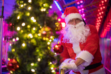 Fototapeta na wymiar Portrait von einem verkleideten Weihnachtsmann, der auf einem Weihnachtsmarkt von Bokeh von bunten Lichtern umgeben ist
