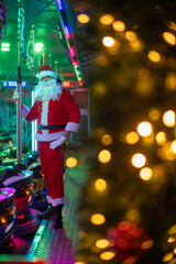 Portrait von einem verkleideten Weihnachtsmann, der auf einem Weihnachtsmarkt von Bokeh von bunten Lichtern umgeben ist