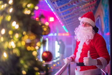Fototapeta na wymiar Portrait von einem verkleideten Weihnachtsmann, der auf einem Weihnachtsmarkt von Bokeh von bunten Lichtern umgeben ist