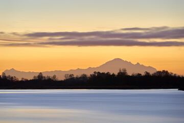 Tranquil Fraser River Dawn. Quiet early morning dawn on the Fraser River, British Columbia. Mt. Baker on the horizon.

