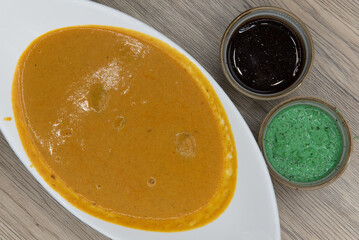 Overhead view of traditional Indian meal consisting of a bowl of shrimp korma and humus dipping sauce for extra flavor