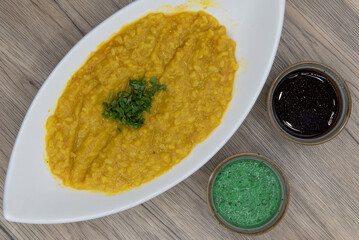 Overhead view of traditional Indian meal starts with a delicious bowl of yellow daal with humus dipping sauce for extra flavor