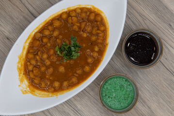 Overhead view of traditional Indian meal starts with a delicious bowl of chana masala with humus...