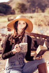 Country girl holding book and cup of coffee