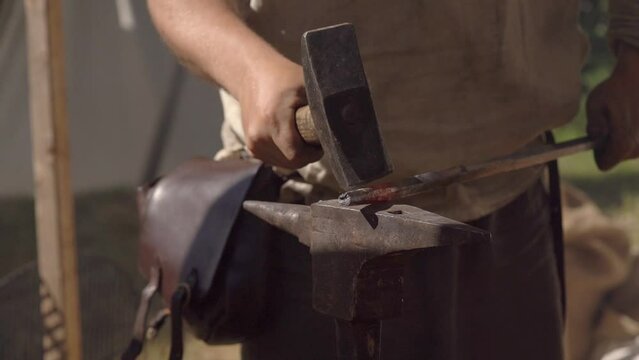 Man Blacksmith At Work Manually Forging and Hitting Metal On Anvil