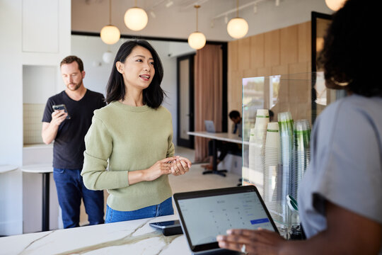 Female customer giving order to at checkout counter in coffee shop