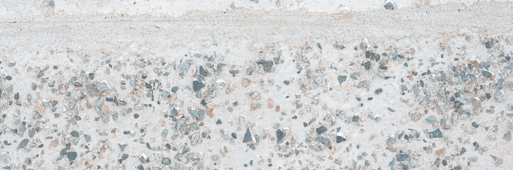 The texture of the old concrete wall. A rough gray concrete surface with many small pebbles. Great for background and design. Close-up.