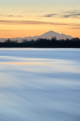 Tranquil Fraser River Dawn Vertical. Quiet early morning dawn on the Fraser River, British Columbia. Mt. Baker on the horizon.

