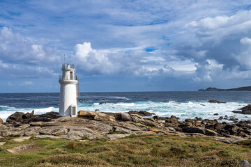 Fototapeta na wymiar Lighthouse in Muxia on the Costa da Morte in Galicia, Spain. Cape Vilan in the background
