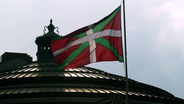Ikurri&ntilde;a flag of Euskadi flies against the background of the city of Bilbao with its thousand-year-old buildings