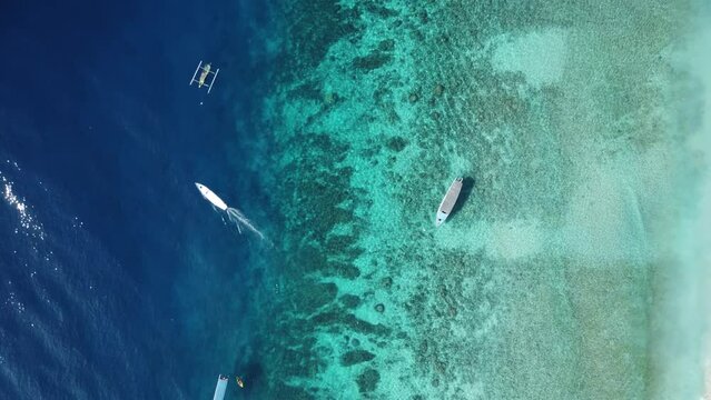 Drone shot of Balis coastline watching the boats drive past 
