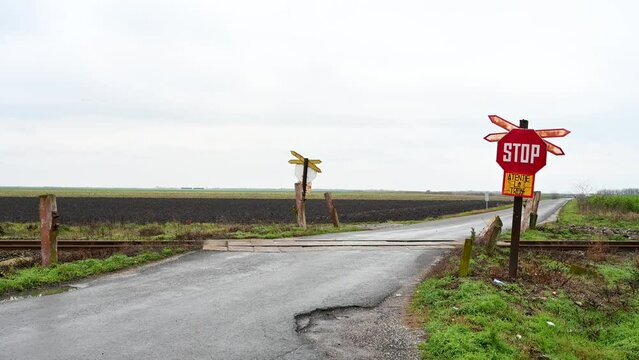 Railway crossing in the field. Crossbuck with stop sign. Warning sign. Railroad crossing.