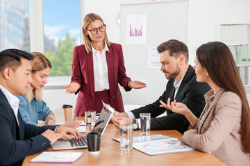 Businesswoman having meeting with her employees in office
