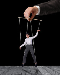 Human relationships demonstrated in puppet show. Worker manipulated by director or manager on black...